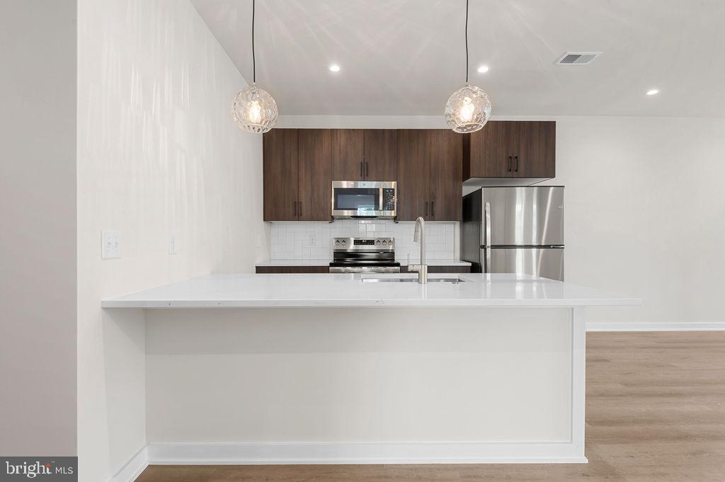 26 South York Road, Unit 210 Hatboro, PA 19040 - Photo 16 of 52 a kitchen with stainless steel appliances a refrigerator sink and microwave