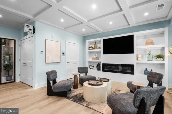 a living room with furniture a flat screen tv and a window