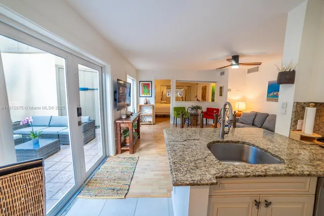 a kitchen view with granite countertop a sink and a counter top space