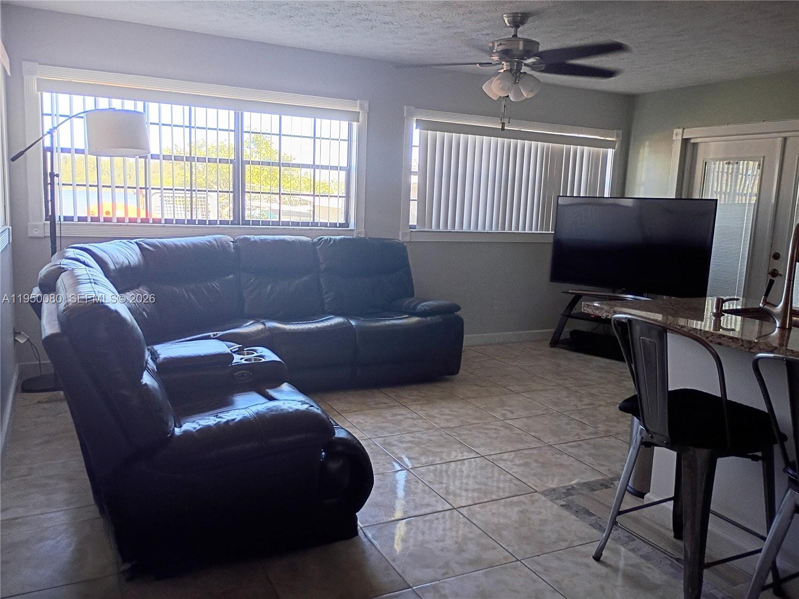 1824 Red Road Clewiston, FL 33440 - Photo 6 of 27 a living room with couches a flat screen tv and a window