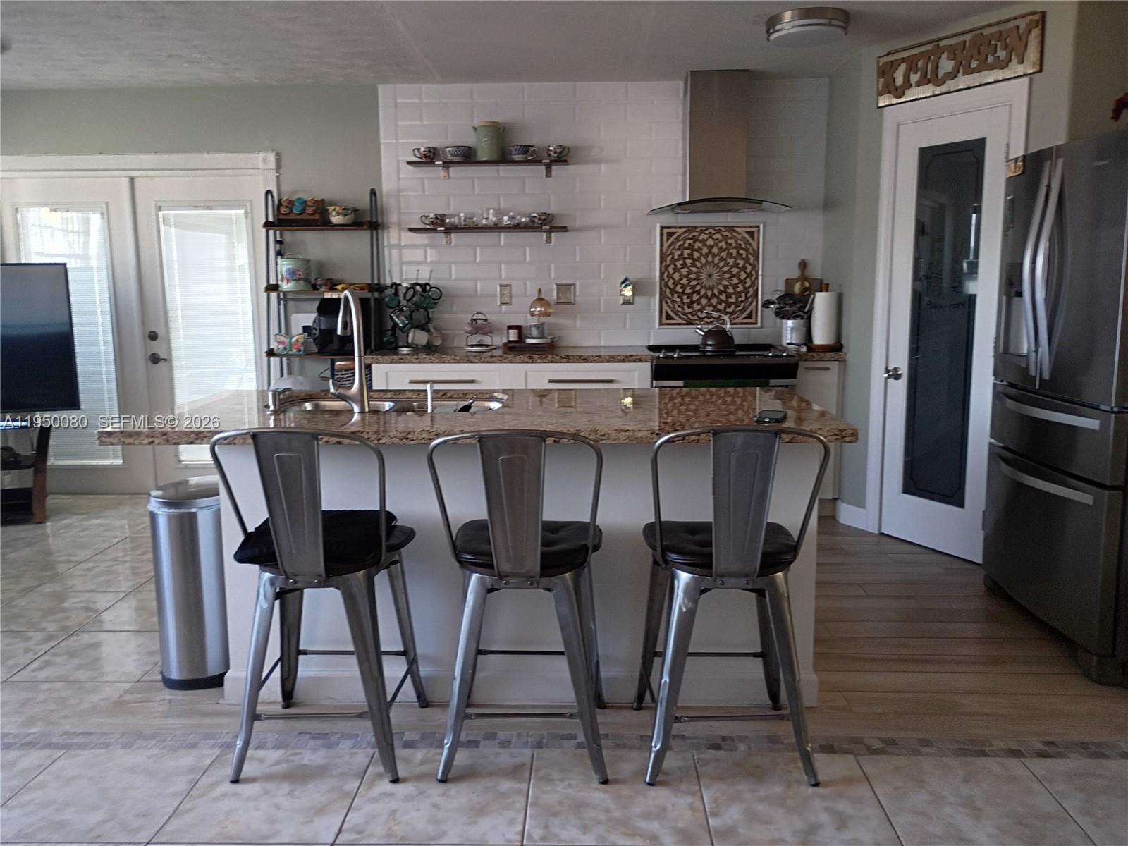 1824 Red Road Clewiston, FL 33440 - Photo 7 of 27 a kitchen with stainless steel appliances granite countertop a table chairs stove and refrigerator