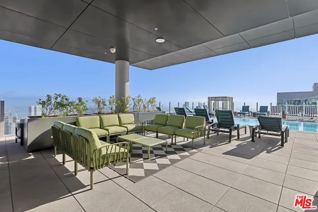 a roof deck with table and chairs a barbeque