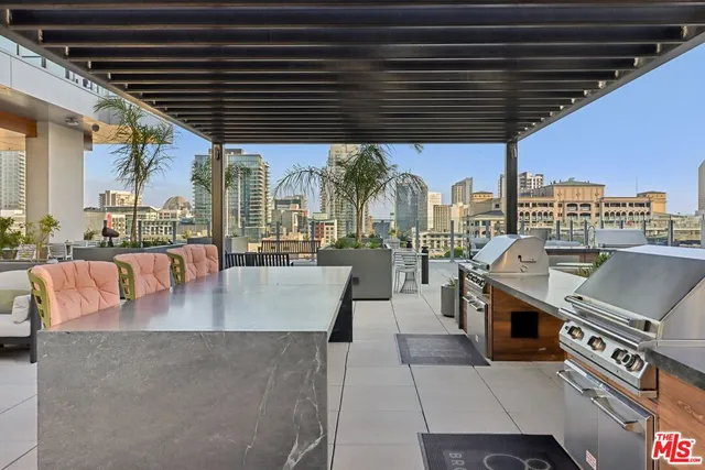 a roof deck with a barbeque grill and couches