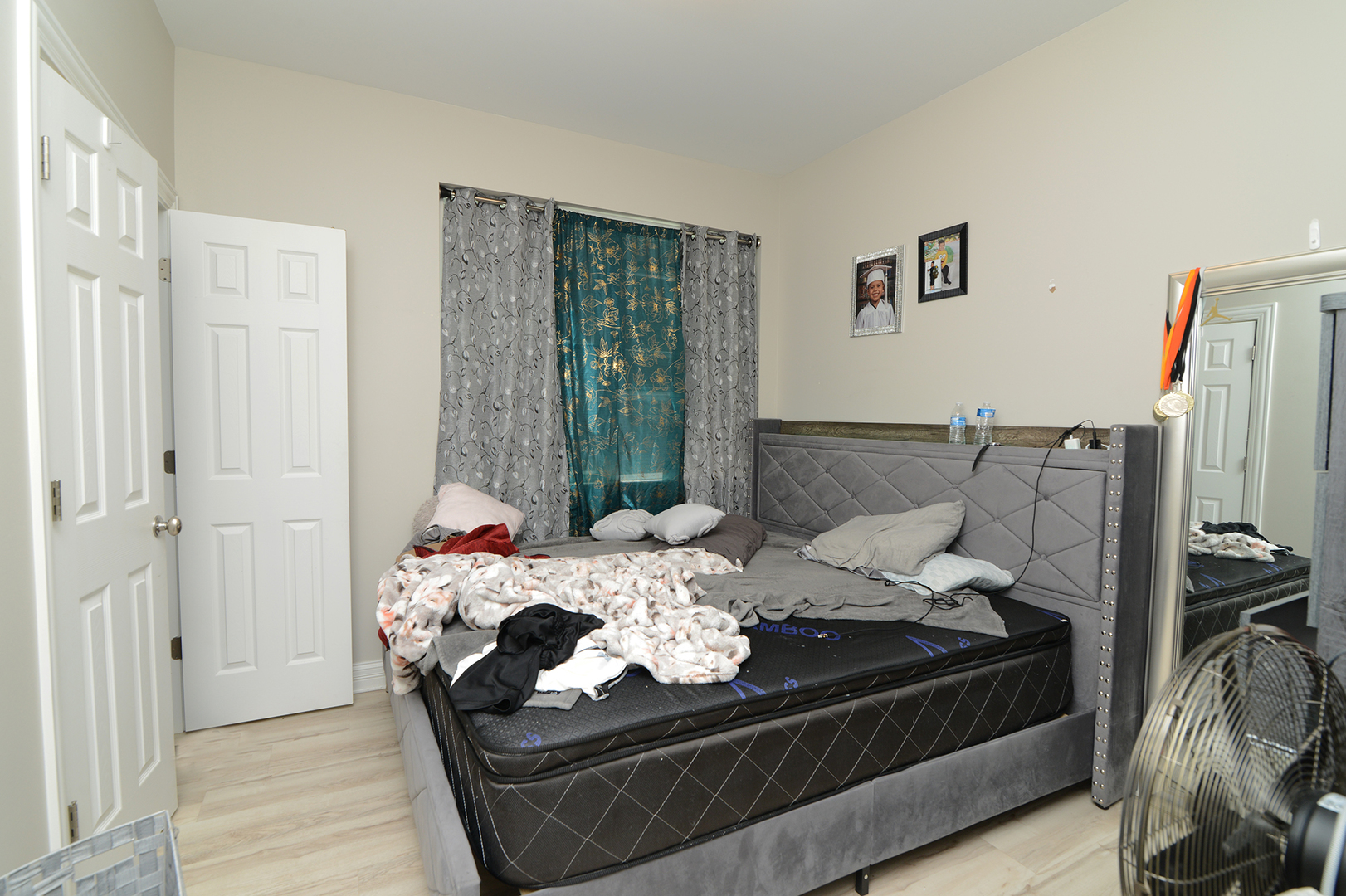 1051 North Springfield Avenue Chicago, IL 60651 - Photo 24 of 50 a bed sitting in a bedroom next to a window with clothes