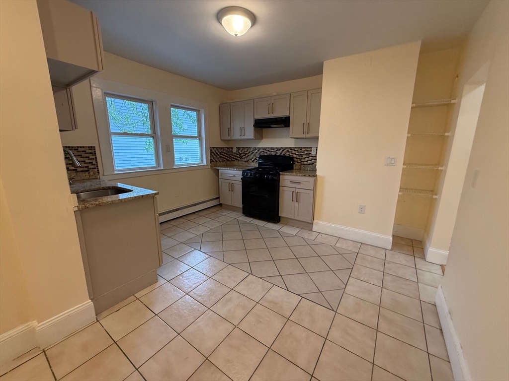 11 Dalrymple Street, Unit 3 Boston, MA 02130 - Photo 9 of 13 a kitchen with stainless steel appliances a refrigerator and a stove top oven