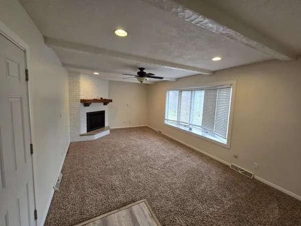 an empty room with windows and cabinet