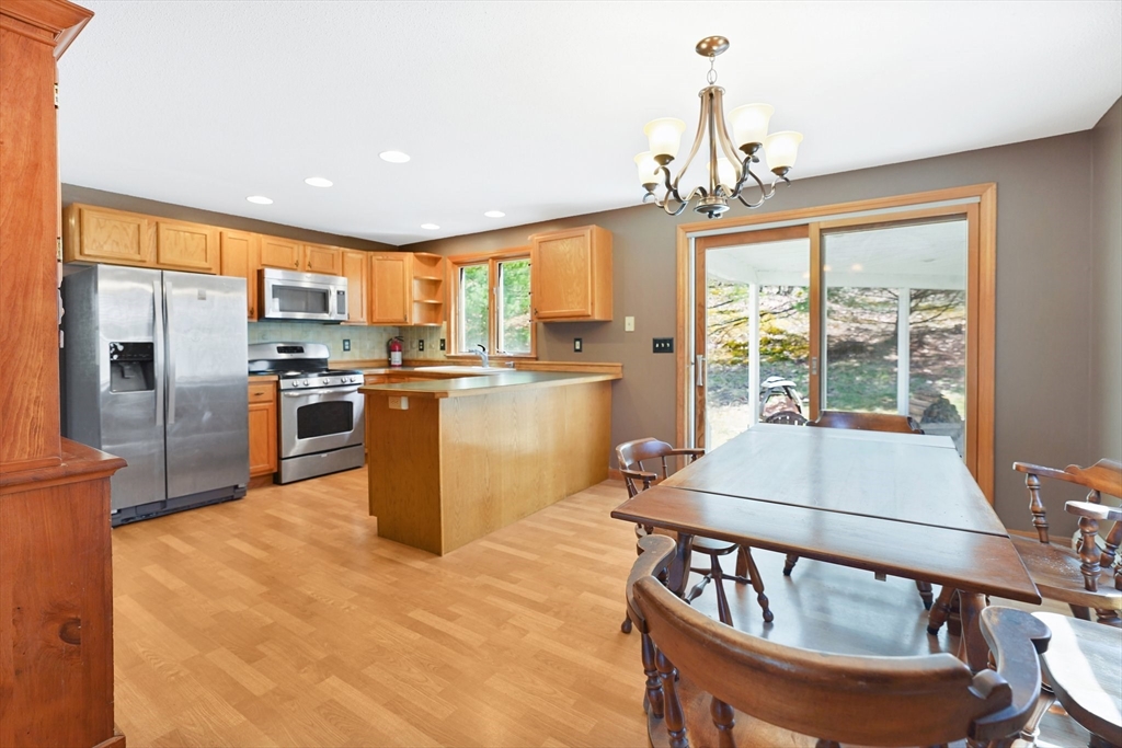 20 Upper Hampden Road Monson, MA 01057 - Photo 10 of 39 a kitchen with stainless steel appliances granite countertop a stove top oven a sink dishwasher a dining table and chairs with wooden floor