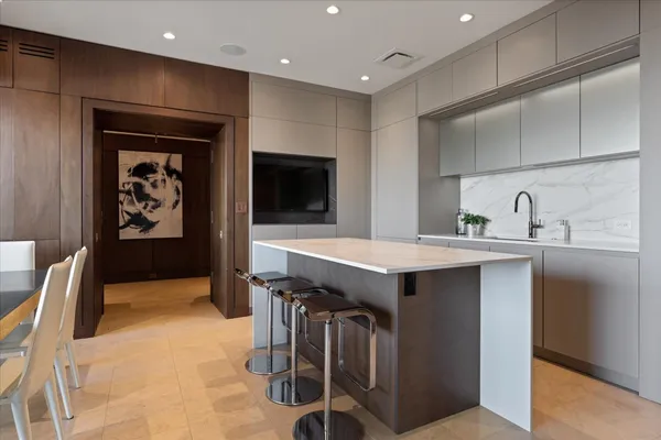 a kitchen with a sink a refrigerator and cabinets