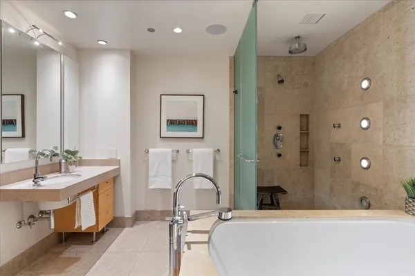 a bathroom with a double vanity sink a mirror and a bathtub