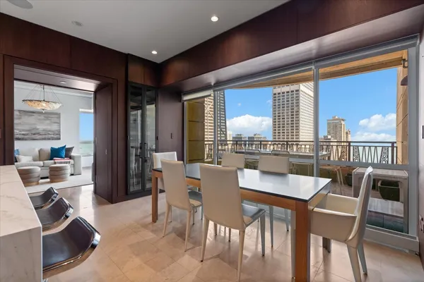 a dining room with furniture and large windows