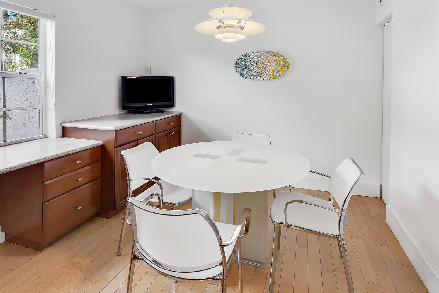 7369 Orangewood Lane, Unit 108 Boca Raton, FL 33433 - Photo 16 of 66 a dining room with wooden floor a chandelier a wooden table and chairs