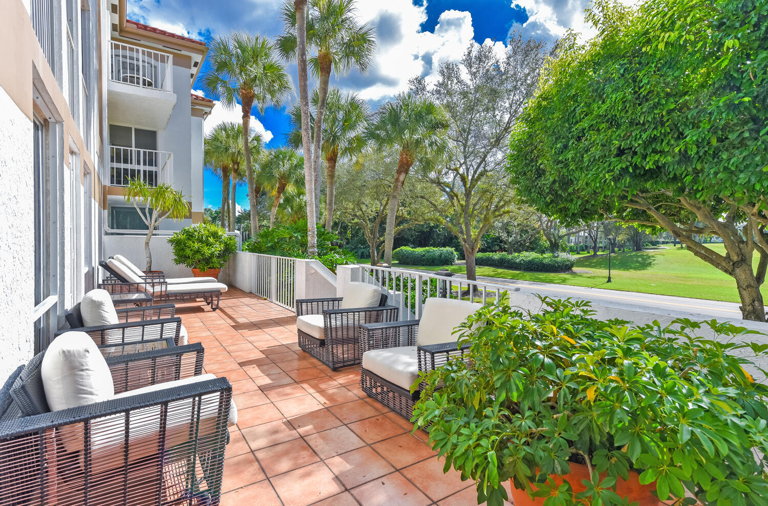 7369 Orangewood Lane, Unit 108 Boca Raton, FL 33433 - Photo 26 of 66 a view of a patio with table and chairs potted plants and large tree