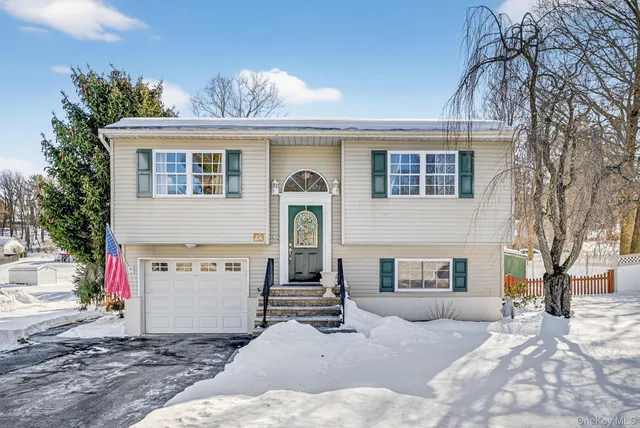 a view of a house with a yard and a garage