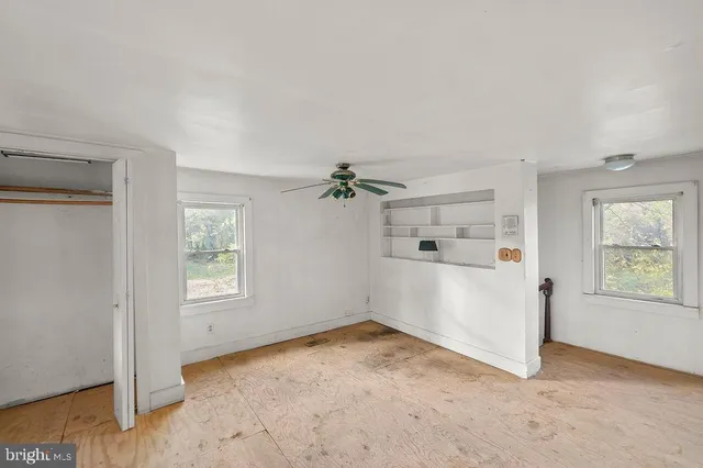 an empty room with windows and cabinet