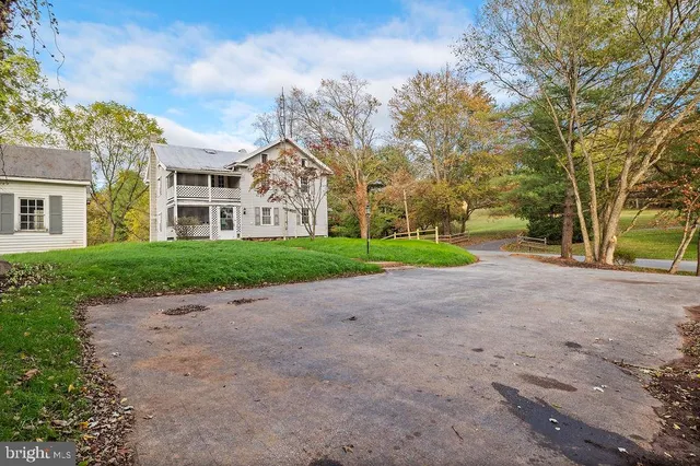 a view of a house with a big yard and large trees