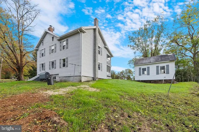 a white house that has a tree in front of it