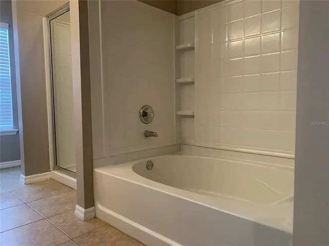 a white bath tub sitting next to a shower