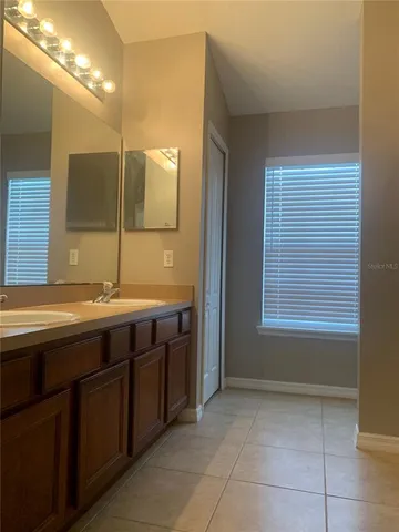 a bathroom with a double vanity sink and a mirror