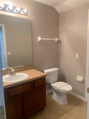 a bathroom with a granite countertop sink a toilet and a mirror