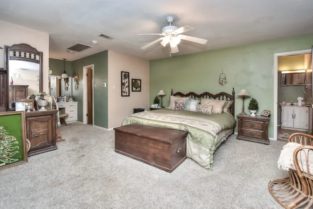 a spacious bedroom with a bed and a chandelier