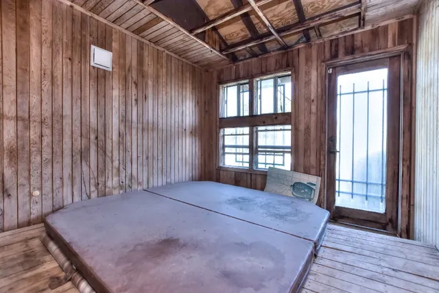 a bed sitting in a spacious bedroom next to a window