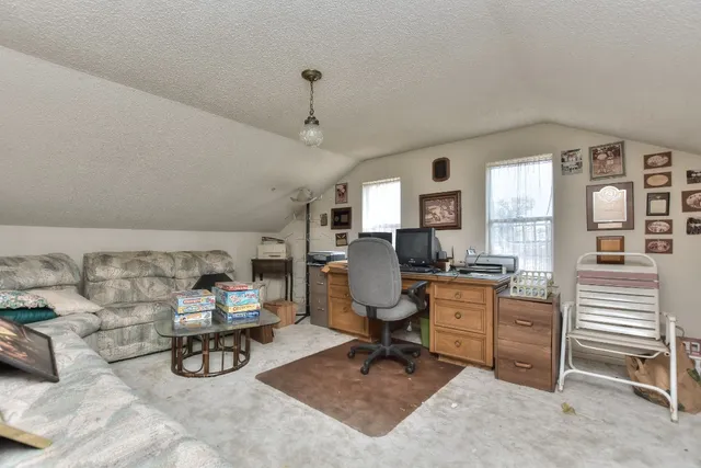 a view of a livingroom with workspace and a window