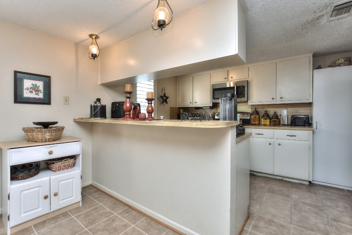 118 Oak Ridge Circle Georgetown, TX 78628 - Photo 8 of 40 a kitchen with stainless steel appliances a refrigerator sink stove and white cabinets