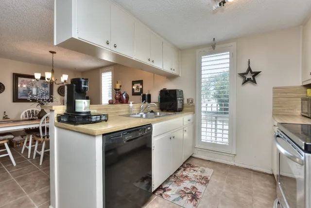 a kitchen with stainless steel appliances granite countertop a sink a stove and a refrigerator