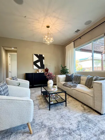 a living room with furniture chandelier and a window