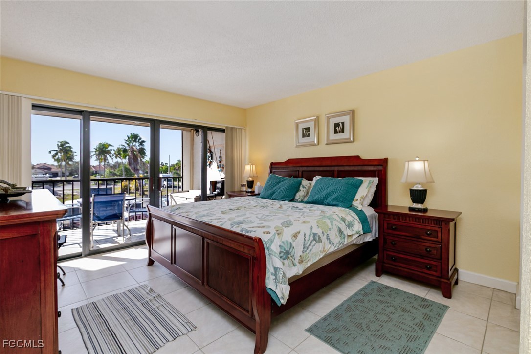 3170 Matecumbe Key Road, Unit 127 Punta Gorda, FL 33955 - Photo 11 of 26 a bedroom with a large bed and a balcony