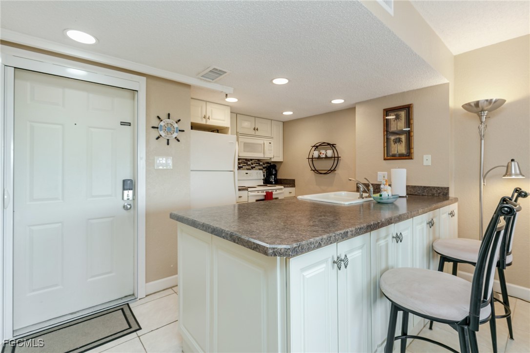 3170 Matecumbe Key Road, Unit 127 Punta Gorda, FL 33955 - Photo 5 of 26 a bathroom with a granite countertop sink a mirror a toilet and shower