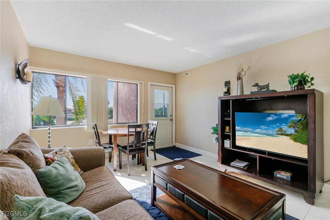 3170 Matecumbe Key Road, Unit 127 Punta Gorda, FL 33955 - Photo 9 of 26 a living room with furniture a flat screen tv and a window
