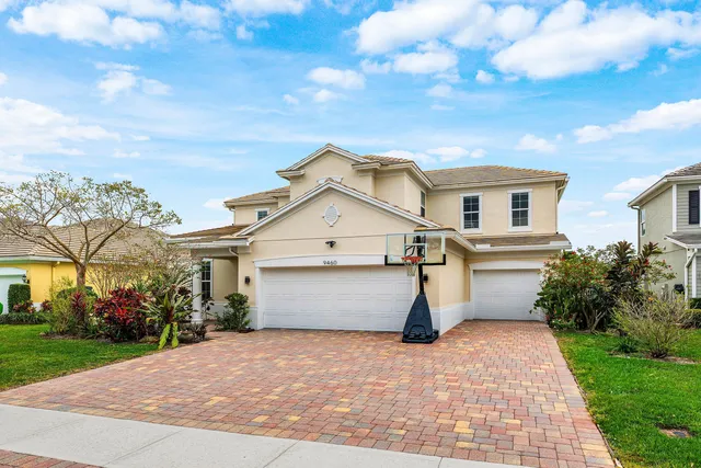 a view of a white house with a yard and potted plants