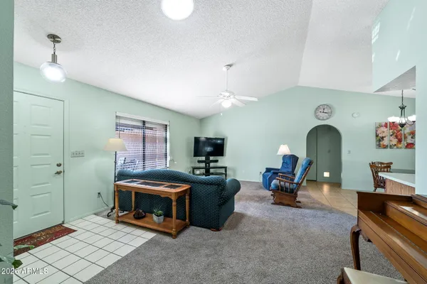 a living room with furniture kitchen view and a chandelier