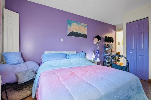 a bedroom with pink bed and a mirror