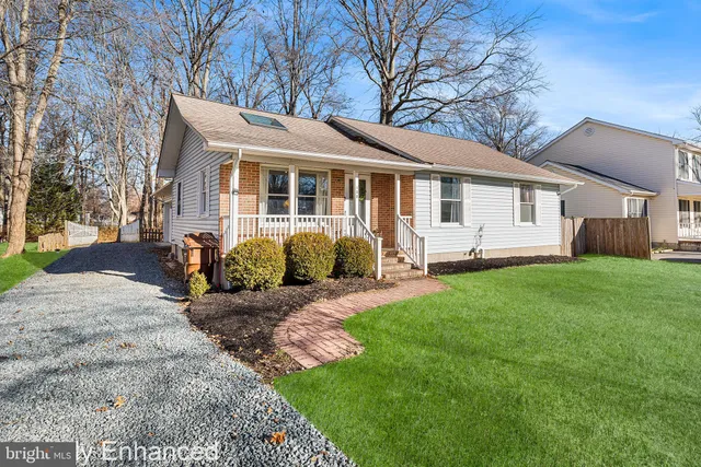 a front view of a house with a yard and trees