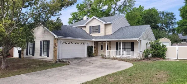 a front view of a house with a garden and yard