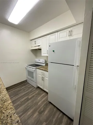 a kitchen with a refrigerator and a stove top oven