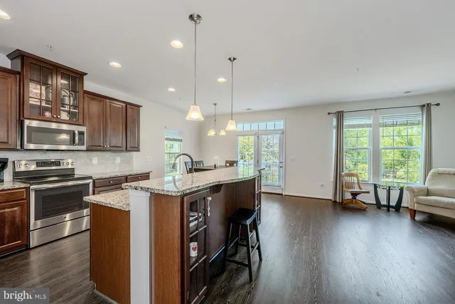 a kitchen with stainless steel appliances granite countertop wooden floors and sink