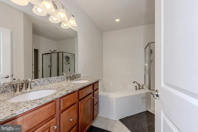 a bathroom with a granite countertop sink mirror and bathtub