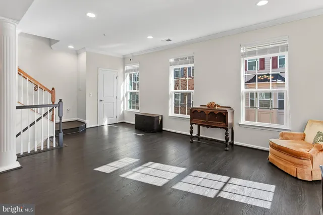 a living room with furniture and stairs with wooden floor