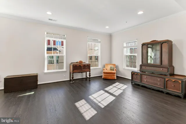 a living room with furniture and dresser with wooden floor