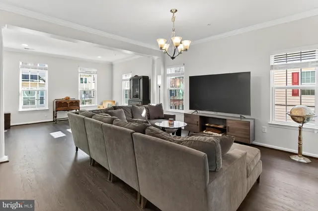 a living room with furniture a flat screen tv and wooden floor