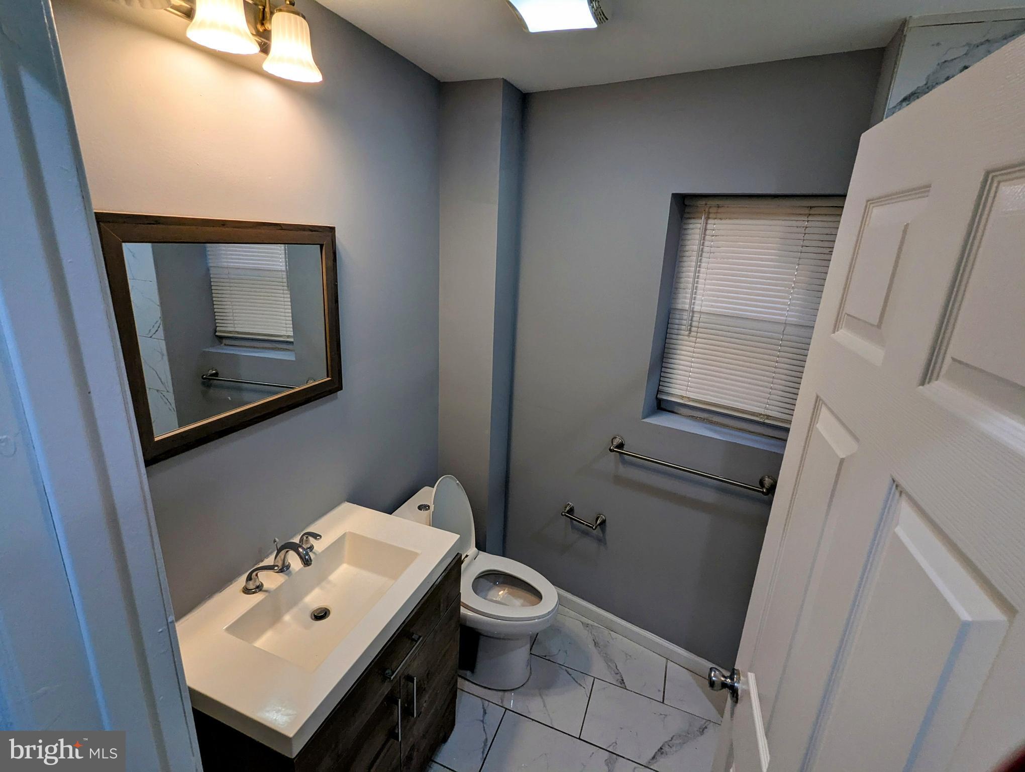 626 North Payson Street Baltimore, MD 21217 - Photo 17 of 23 a bathroom with a toilet sink and mirror