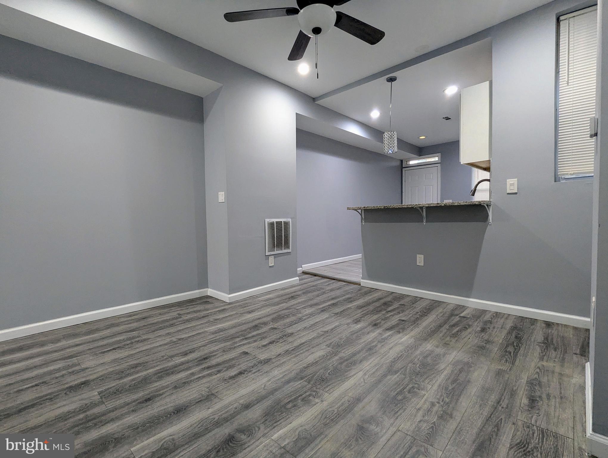 626 North Payson Street Baltimore, MD 21217 - Photo 6 of 23 an empty room with wooden floor and windows