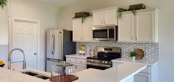 a kitchen with stainless steel appliances a refrigerator a sink a stove and cabinets