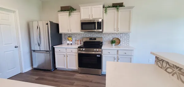 a kitchen with a refrigerator stove and white cabinets