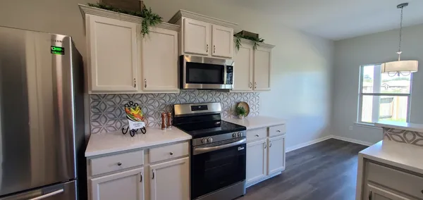 a kitchen with stainless steel appliances a stove microwave and refrigerator