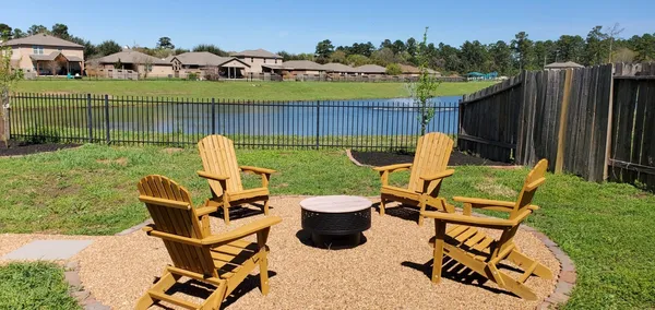 a view of a backyard with table and chairs potted plants and wooden fence