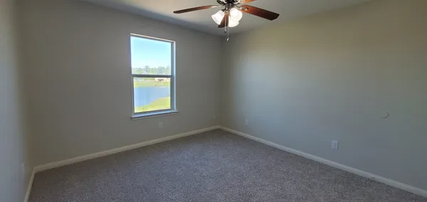 an empty room with a ceiling fan and a window